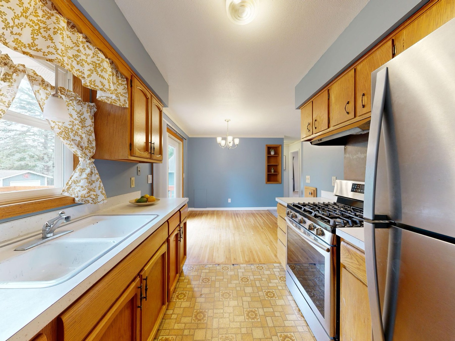 Dated 1970s kitchen with worn oak cabinets and laminate counters, before renovation