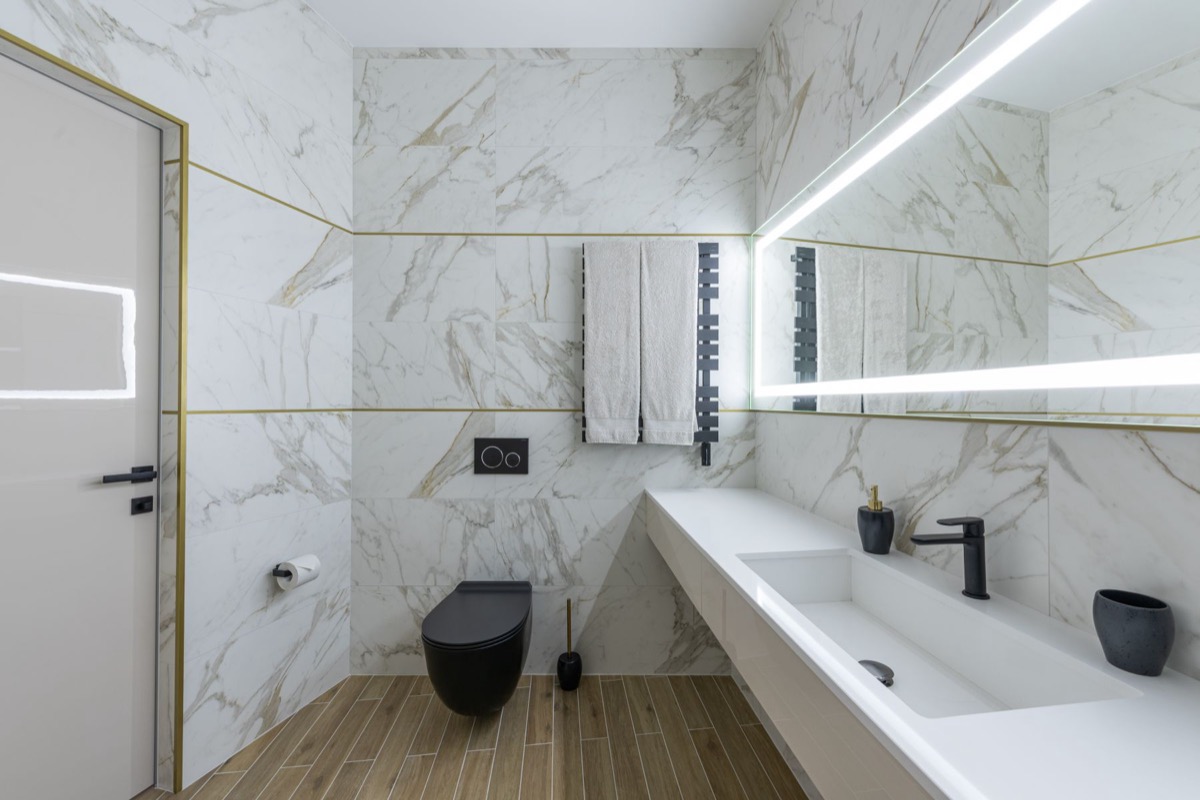 Modern bathroom in book-matched marble with backlit mirror