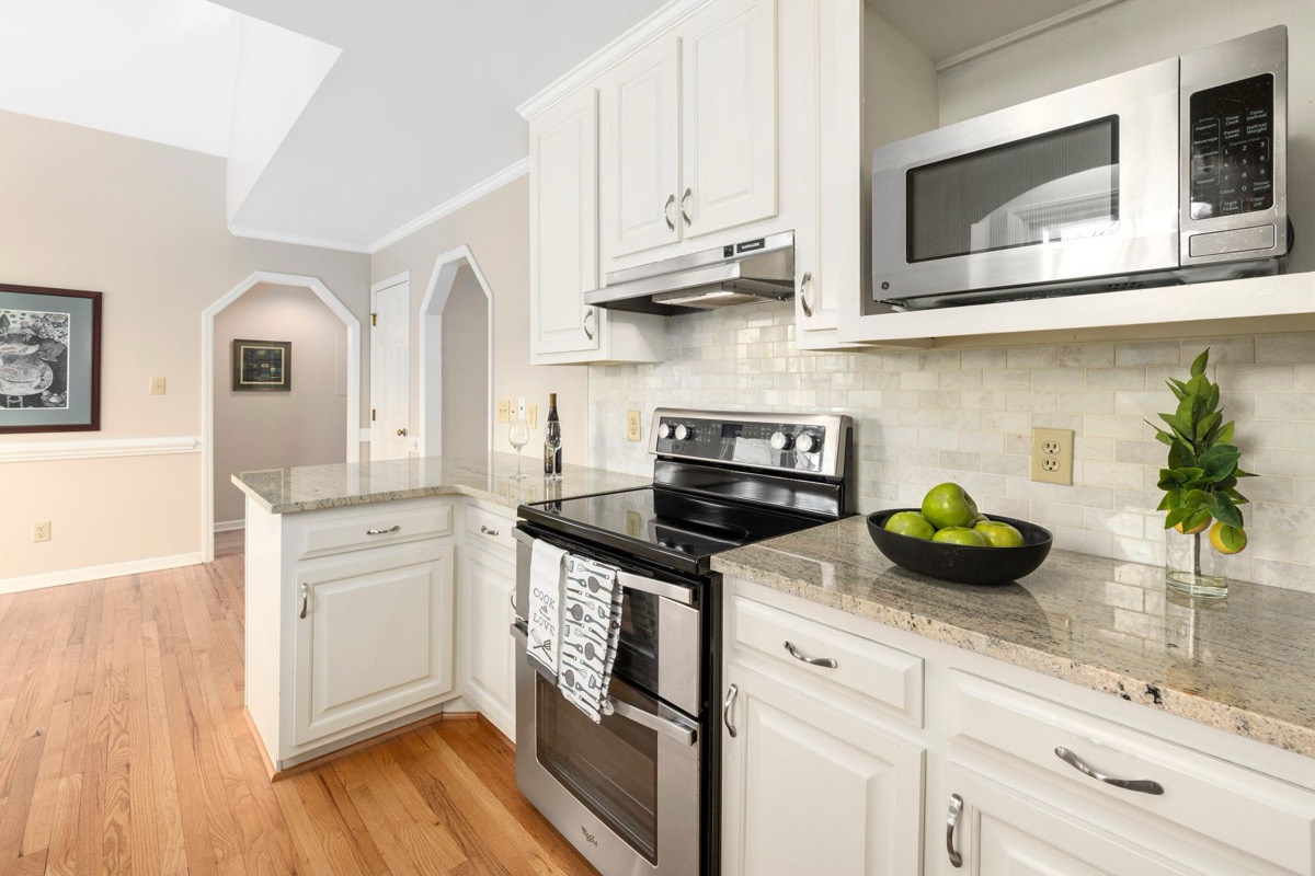 Classic white kitchen with stone counters and brass hardware